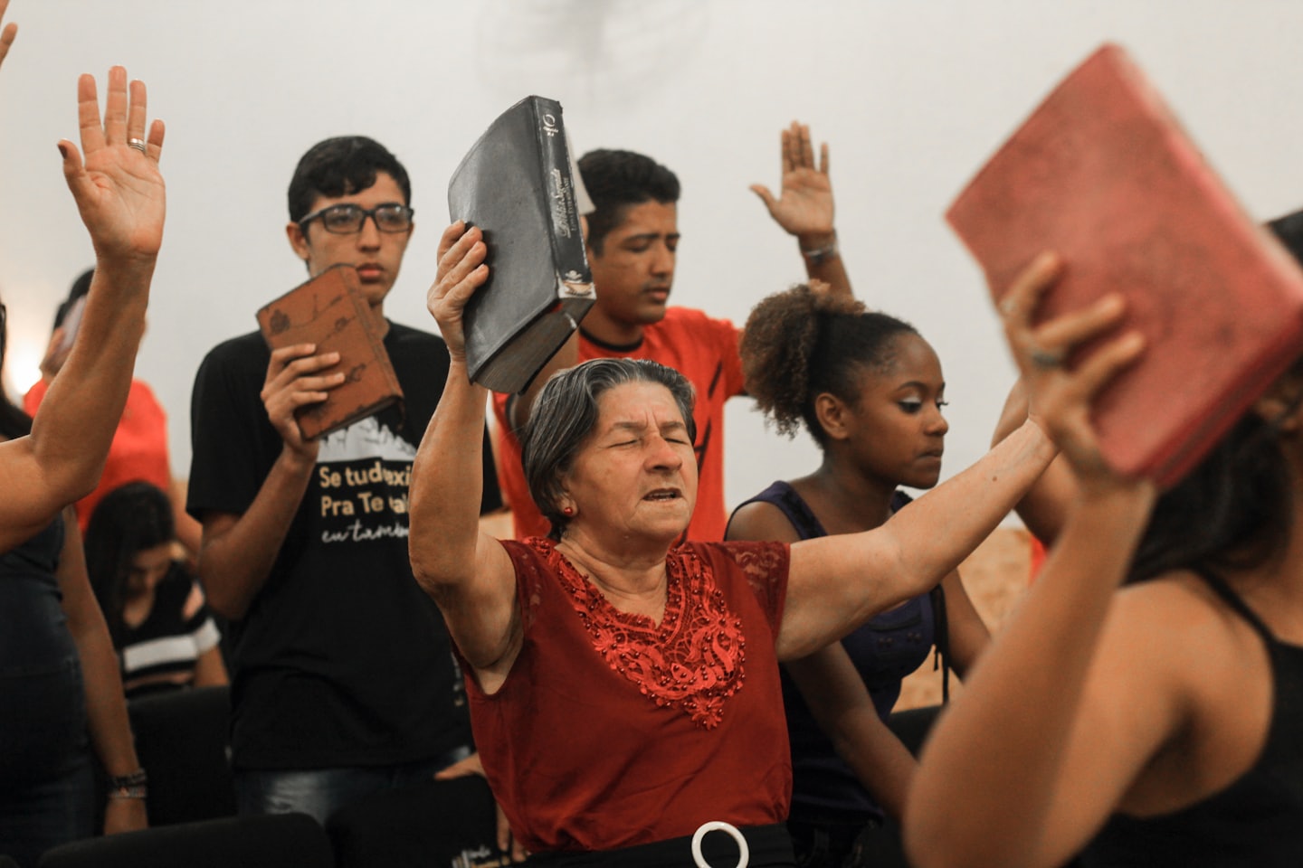 People gathered indoors with hands raised in worship.